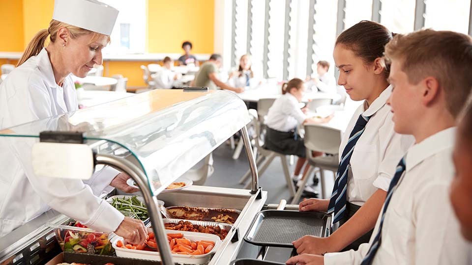 Secondary school children choose food in the school canteen